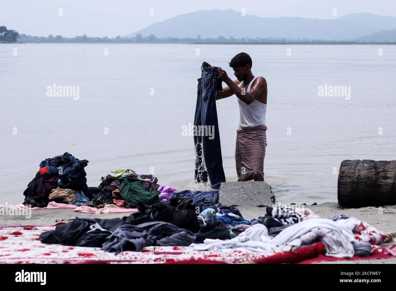 Un homme lavant des vêtements sur les rives du fleuve Brahmaputra à Guwahati, en Inde, le 09 juin 2021. (Photo de David Talukdar/NurPhoto) Banque D'Images
