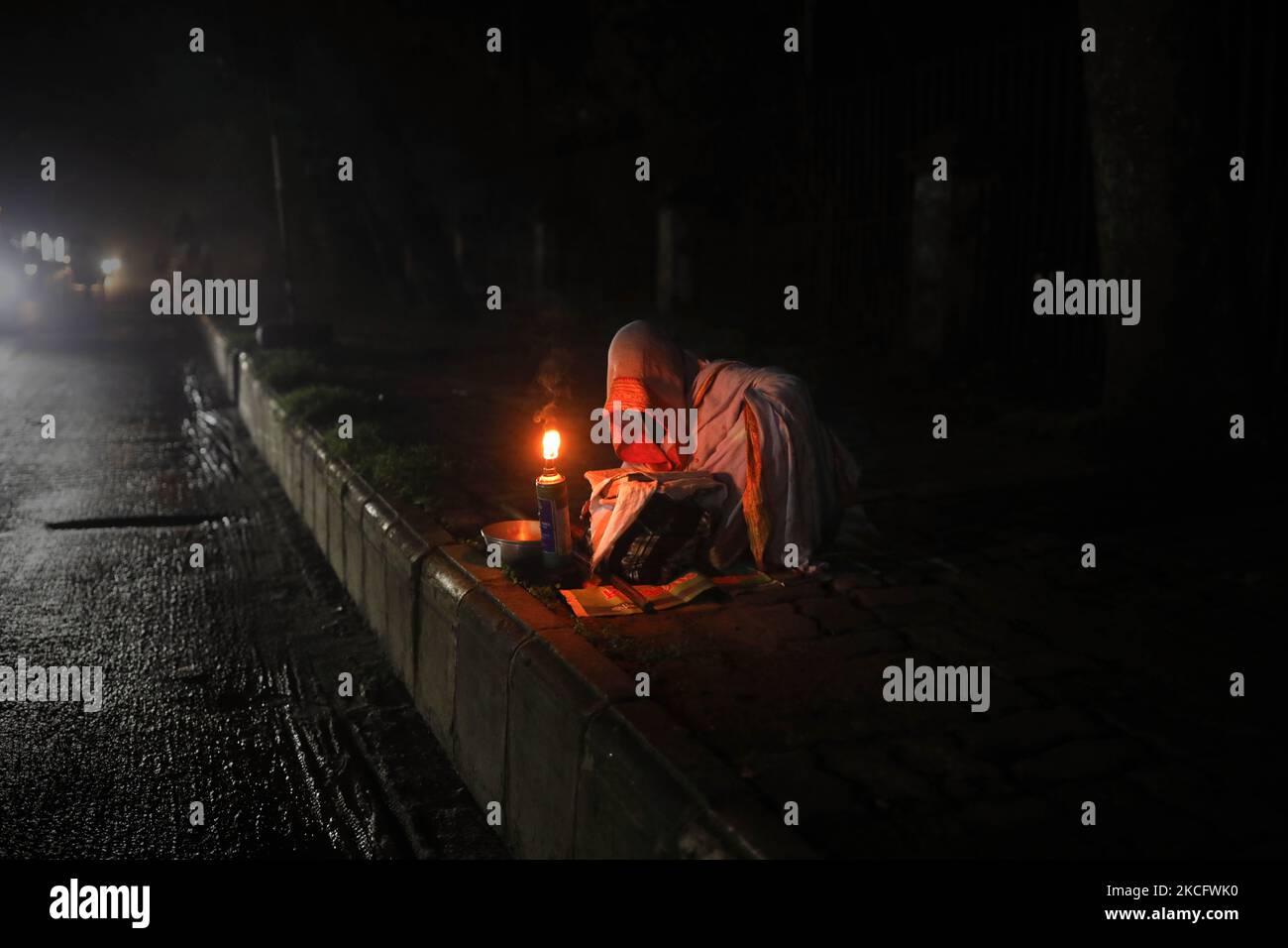 Une femme exécute le Saint Coran au milieu de la nuit avec une bougie dans la zone universitaire de Dhaka à Dhaka, au Bangladesh, sur 10 juin 2021. (Photo de Kazi Salahuddin Razu/NurPhoto) Banque D'Images