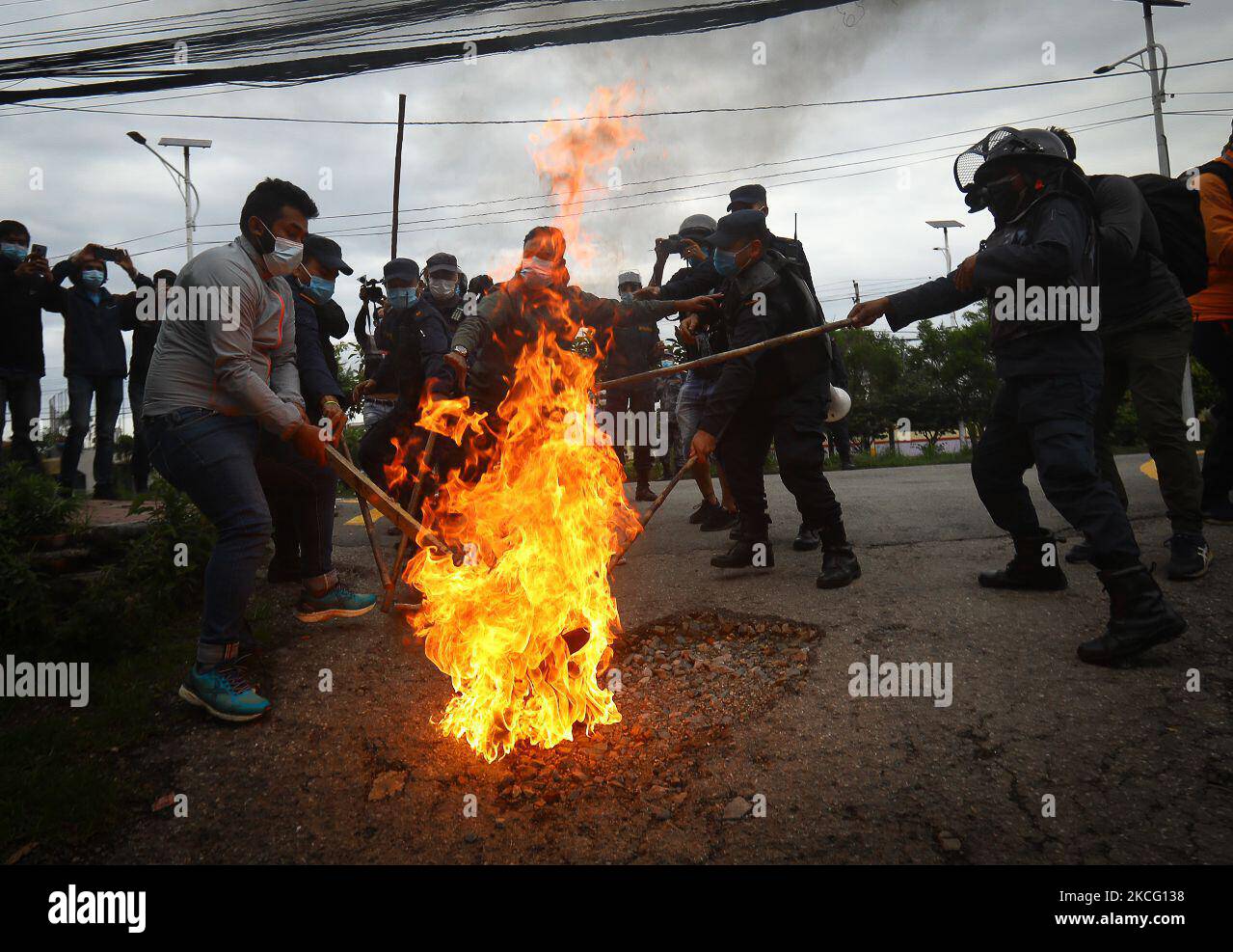 Le personnel de police tente d'éveiller une effigie du Premier ministre du Népal, KP Sharma Oli, incendiée par l'alliance de l'opposition lors d'une manifestation contre le mouvement inconstitutionnel du gouvernement, notamment la dissolution de la Chambre des représentants et des élections anticipées dans le cadre du confinement de la pandémie du coronavirus à Katmandou, au Népal samedi, 12 juin, 2021. (Photo par Saroj Baizu/NurPhoto) Banque D'Images