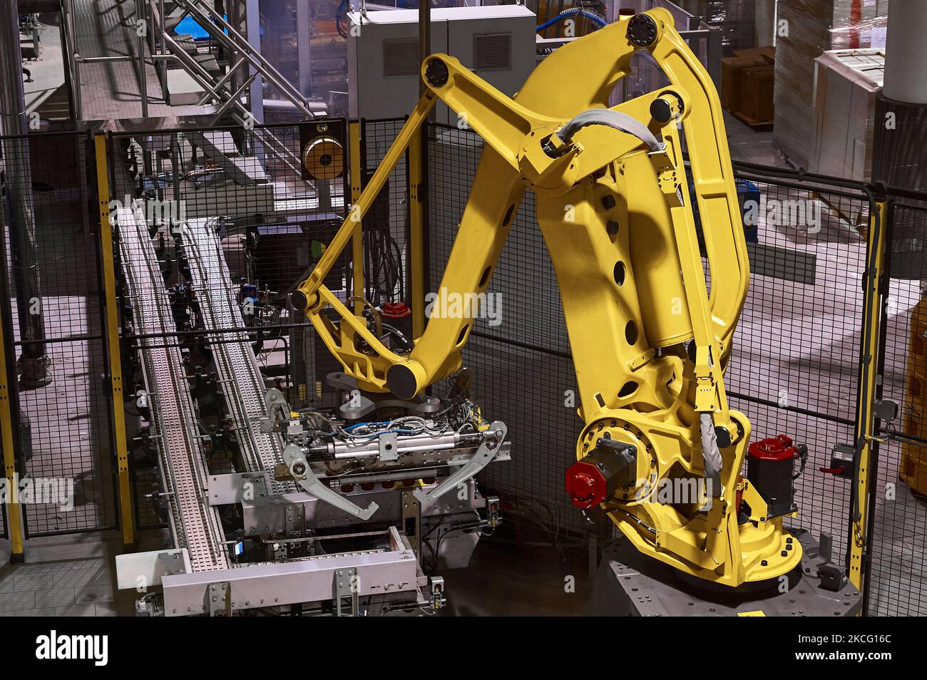 Bras robotisé jaune équipé d'un système de préhension de caisse. Banque D'Images