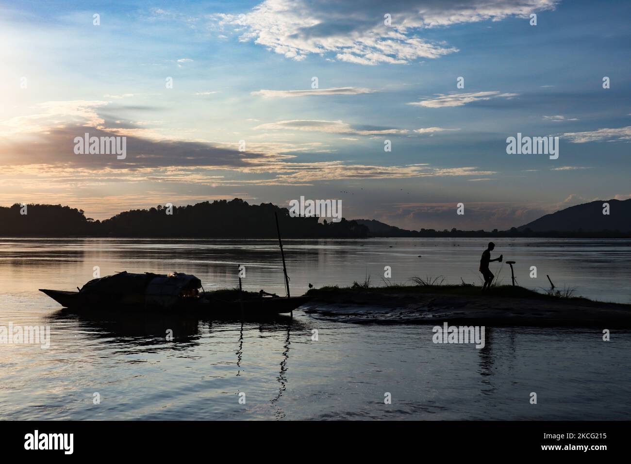 Pêcheur travaillant dans le fleuve Brahmaputra au coucher du soleil, à Guwahati, Assam, Inde, le 13 juin 2021. (Photo de David Talukdar/NurPhoto) Banque D'Images