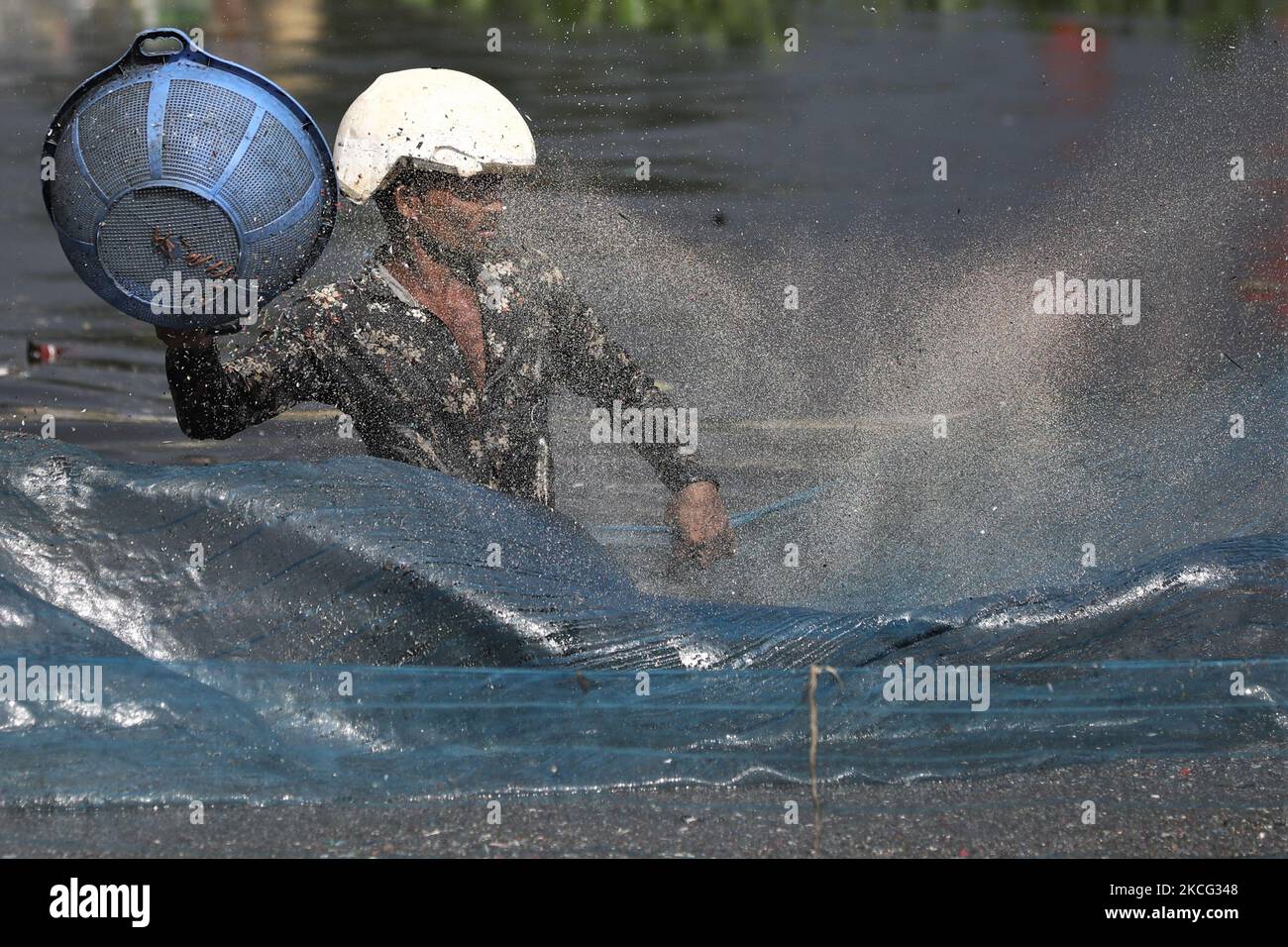 Un travailleur nettoie et collecte les pièces des bouteilles en plastique qui seront recyclées plus tard dans le fleuve Buriganga à Dhaka, au Bangladesh, sur 14 juin 2021. Le fleuve Buriganga, qui coule par la ville de Dhaka, aujourd'hui l'un des fleuves les plus pollués du monde, en raison du déversement endémique des gaspillages humains et industriels. (Photo de Syed Mahamudur Rahman/NurPhoto) Banque D'Images Un travailleur nettoie et collecte les pièces des bouteilles en plastique qui seront recyclées plus tard dans le fleuve Buriganga à Dhaka, au Bangladesh, sur 14 juin 2021. Le fleuve Buriganga, qui coule par la ville de Dhaka, aujourd'hui l'un des fleuves les plus pollués du monde, en raison du déversement endémique des gaspillages humains et industriels. (Photo de Syed Mahamudur Rahman/NurPhoto) Banque D'Images