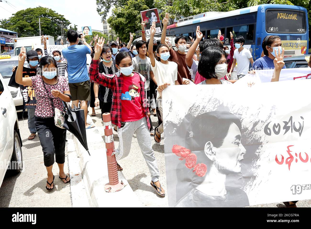 Les manifestants tiennent une bannière du dirigeant civil du Myanmar arrêté Aung San Suu Kyi alors qu'ils marchent lors d'une foule éclair de protestation contre le coup d'État militaire à Yangon, au Myanmar, sur 19 juin 2021. (Photo de Myat Thu Kyaw/NurPhoto) Banque D'Images