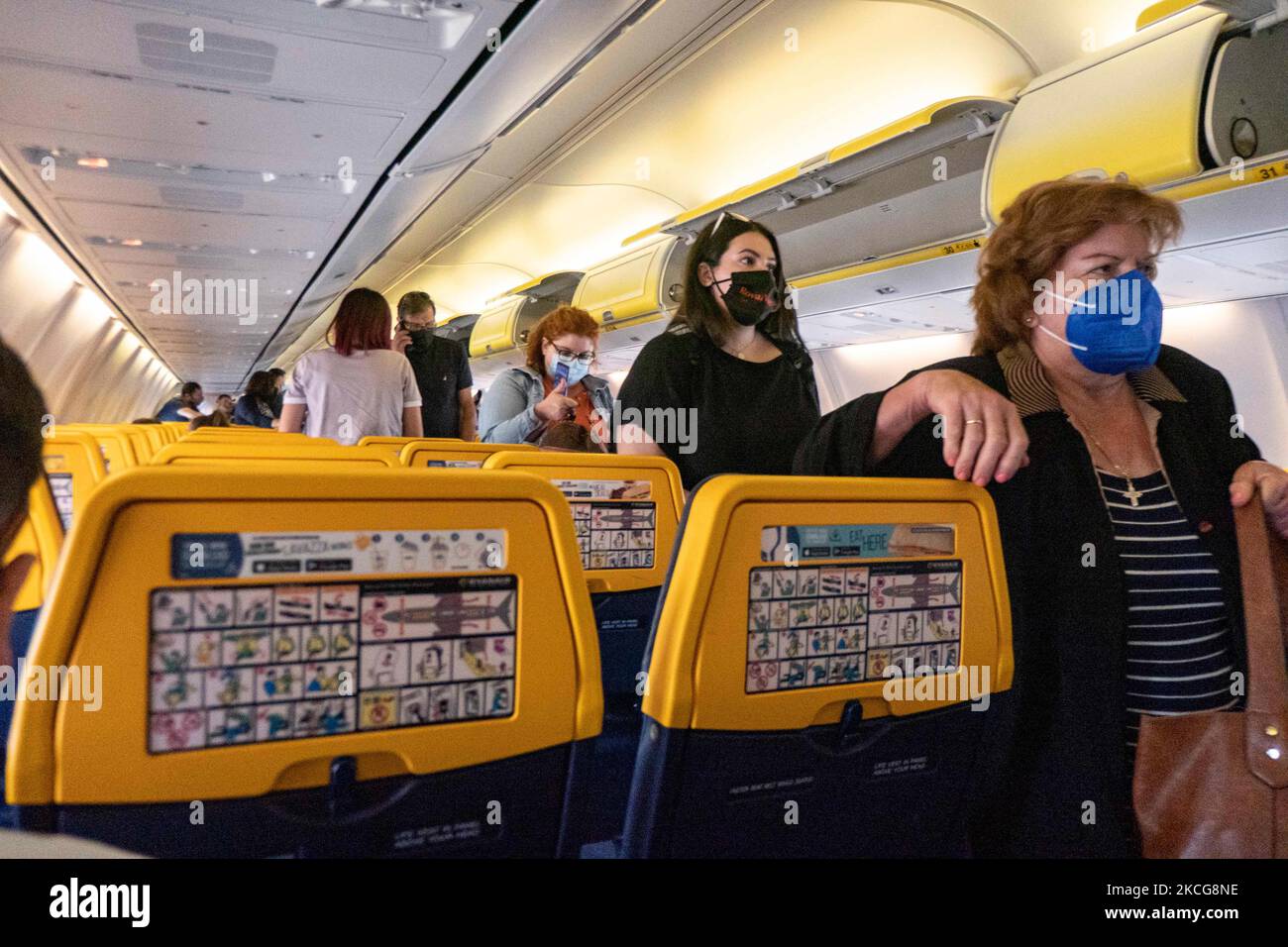 Pendant le vol, les passagers portent un masque facial dans la cabine. Vol pendant la pandémie du coronavirus Covid-19 à l'intérieur d'un Boeing 737-800 de Ryanair transporteur à bas prix avec la destination Chania en Crète Island, une destination de vacances populaire. À l'intérieur de l'avion est obligatoire de porter des masques pour les passagers et l'équipage de conduite, l'hôtesse d'air, etc. Alors que les gens ont besoin d'un test COVID négatif pour monter à bord de l'avion comme mesure de sécurité, tandis que l'industrie de l'aviation et du tourisme a du mal à revenir à la normalité. La Grèce tente de stimuler son tourisme et de donner des privilèges pour se faire vacciner contre le COV Banque D'Images