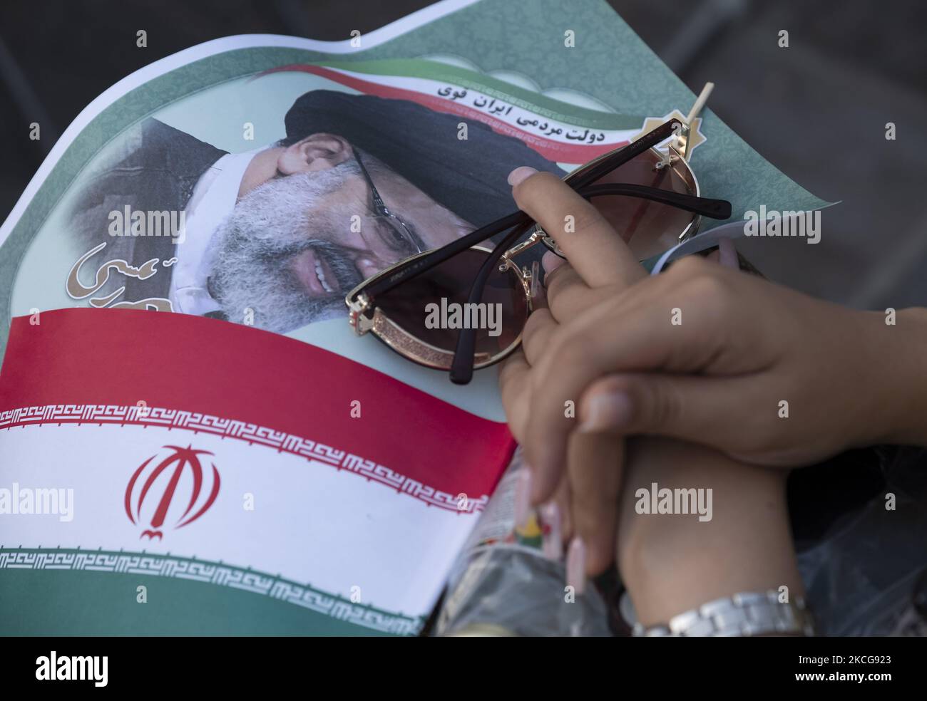 Une femme partisane du président iranien élu, Ebrahim Raisi, détient une affiche électorale de Raisi et un drapeau de l’Iran, tout en assistant à un rassemblement pour célébrer la victoire de Raisi aux élections présidentielles de 18 juin en Iran, dans le sud de Téhéran sur 19 juin 2021. Raisi a remporté les élections présidentielles iraniennes et a élu le nouveau président iranien. (Photo de Morteza Nikoubazl/NurPhoto) Banque D'Images