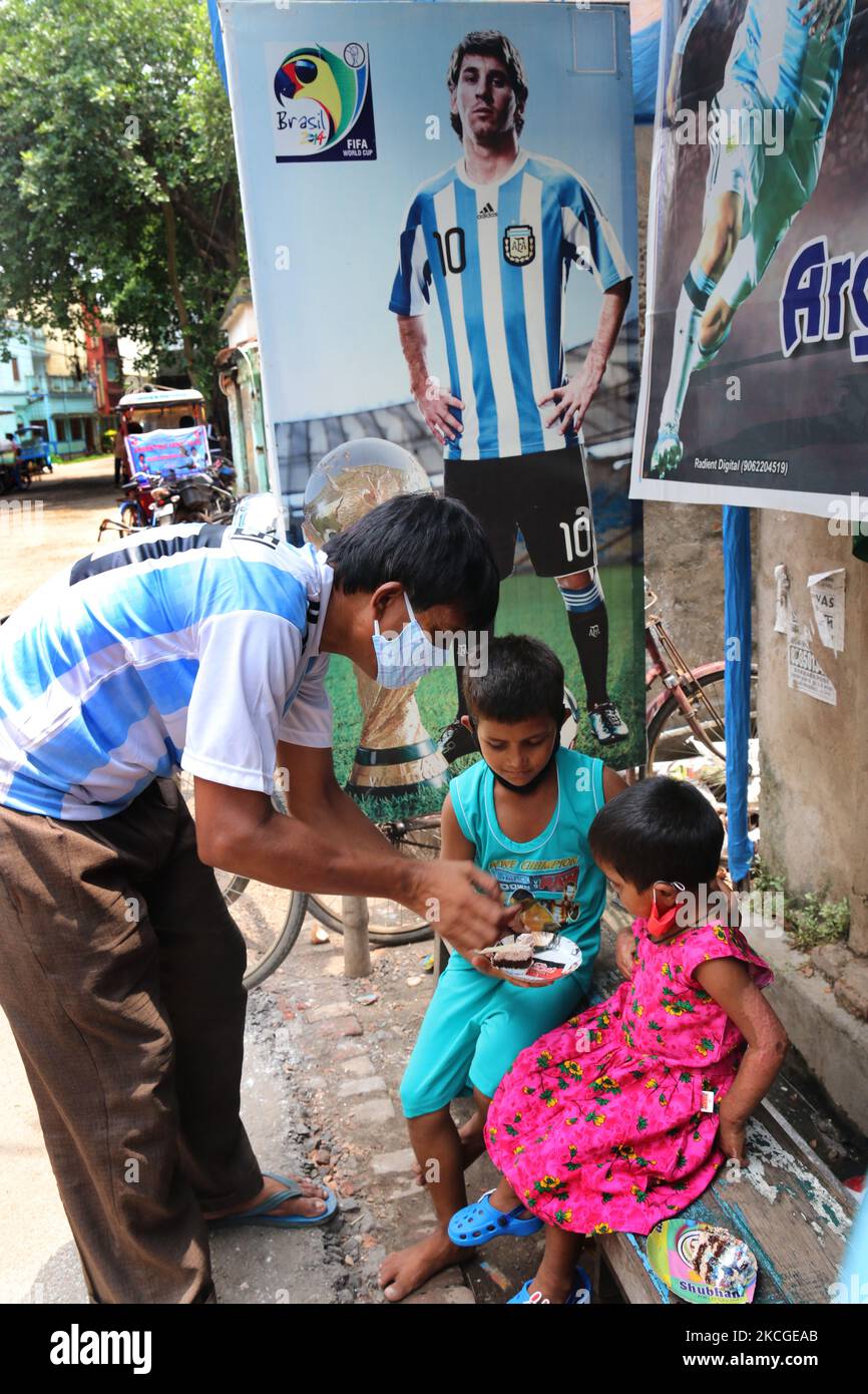 Shib Shankar Patra ( L ), fan de football de l'équipe Argentine, gâteau dristribute lors de la célébration de l'anniversaire 34th du footballeur professionnel de renommée mondiale Lionel Messi au nord 24 Pargana Kolkata à 27 kilomètres au nord, Bengale occidental, Inde, on 24 juin 2021. (Photo de Debajyoti Chakraborty/NurPhoto) Banque D'Images