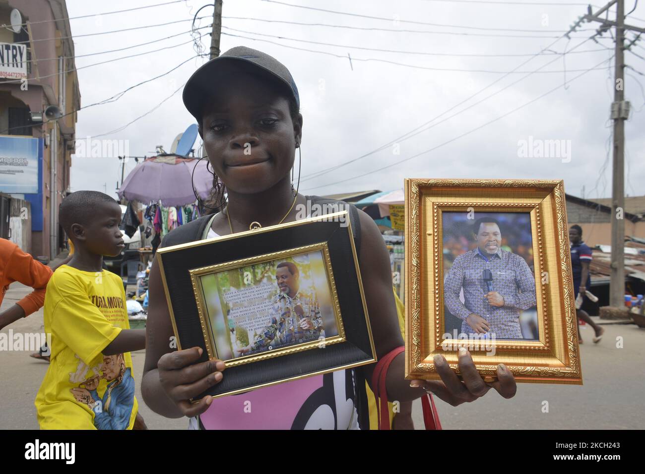 Une femme tenant une image du fondateur de la Synagogue Eglise de toutes les nations (SCOAN), le prophète Temitope Balogun Josuha arrive à son dernier lieu de repos dans les locaux de l'église dans le district d'Ikotun, Lasgos, Nigeria, sur 8 juillet 2021. Le religieux décédé samedi, 5 juin 2021, une semaine avant son anniversaire de 58th ans, le prédicateur serait mis au repos dans un programme funèbre d'une semaine qui comprend la procession aux chandelles, le mentir dans l'État et le service d'hommage, les services de chants/toutes les louanges de nuit et les services de mentir-à-repos et l'internement. La cause de sa mort n'a pas été révélée. (Photo Banque D'Images