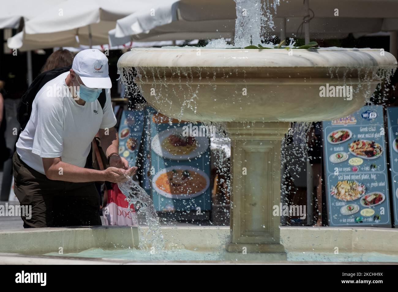 Les gens marchent dans le centre de la Canée, en Grèce, pendant la montée des températures, en passant à côté de la fontaine sur 22 juillet 2021. (Photo de Nikolas Kokovovlis/NurPhoto) Banque D'Images