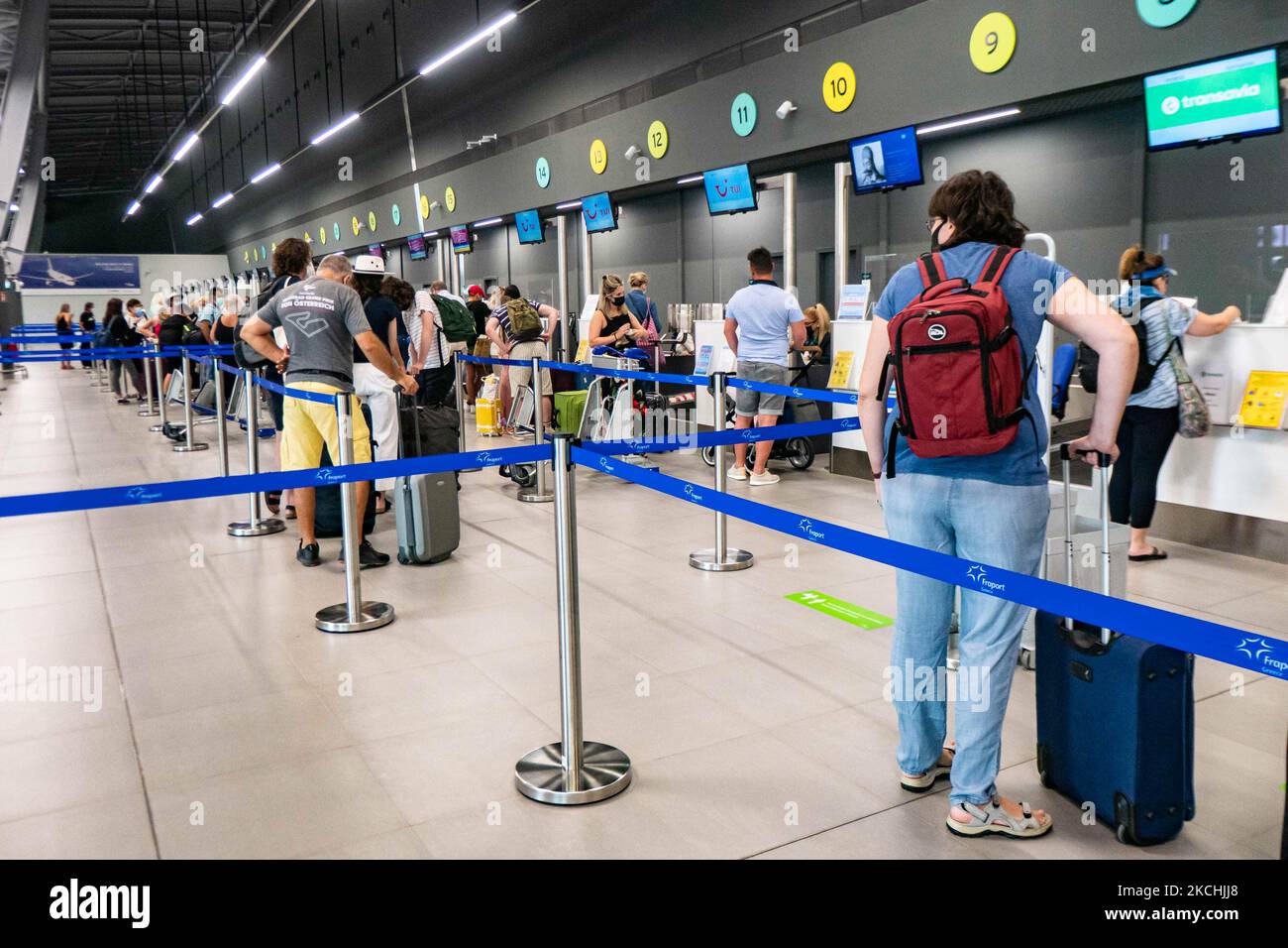 Personnes dans le hall des départs du nouveau T2 avec les comptoirs d'enregistrement à l'aéroport international de Thessalonique Makedonia SKG LGTS dans le nord de la Grèce. Passagers avec masque facial comme vu à l'intérieur et à l'extérieur du terminal de l'aéroport. Les passagers arrivant utilisent l'aéroport pour se rendre aux îles ou pour se rendre à des destinations de vacances proches comme Halkidiki, avec des tests PCR négatifs ou un passeport de vaccination verte. La Grèce est une destination de voyage populaire avec des plages célèbres et une industrie touristique fortement développée, avec une longue saison touristique car elle est située dans la partie sud de l'Europe dans les eaux méditerranéennes. GR Banque D'Images