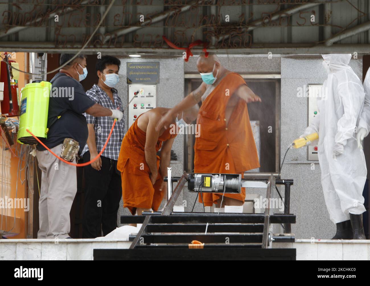 Un homme vaporise des désinfectants sur un moine bouddhiste à un crématorium lors d'une cérémonie funéraire à Wat Bang Muang, dans la province de Nonthaburi, à la périphérie de Bangkok, sur 24 juillet 2021. La charge de travail quotidienne de Thalilands Covid-19 a augmenté de 14 260 samedi, portant le total à 481 967, avec 119 décès. (Photo de Chaiwat Subprasom/NurPhoto) (photo de Chaiwat Subprasom/NurPhoto) Banque D'Images