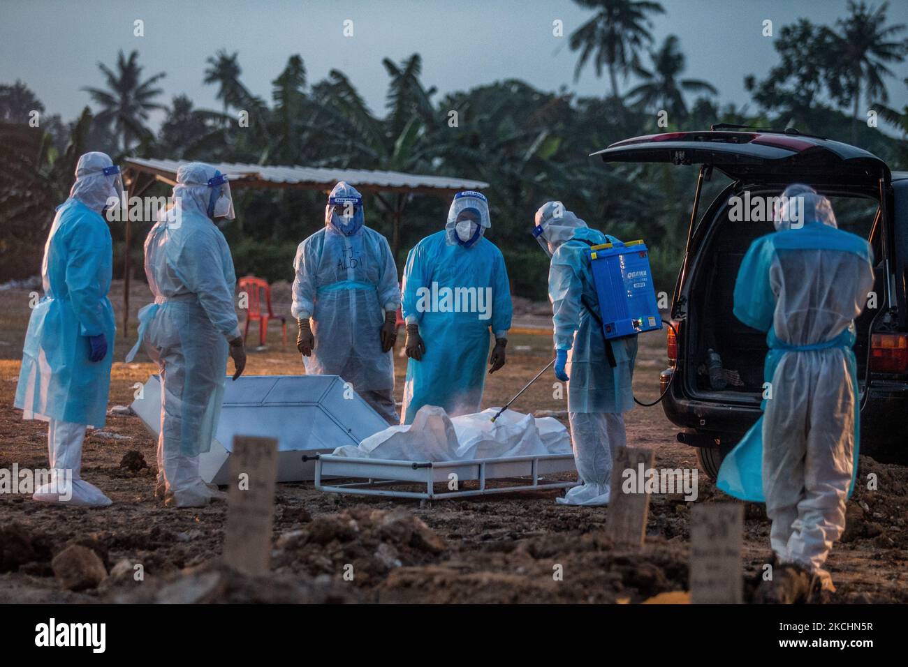 Les travailleurs funéraires portant un désinfectant protecteur le corps d'une victime du coronavirus Covid-19 avant l'enterrement dans un cimetière de Klang, à l'extérieur de Kuala Lumpur, en Malaisie, sur 24 juillet 2021. (Photo de Mohd Firdaus/NurPhoto) Banque D'Images