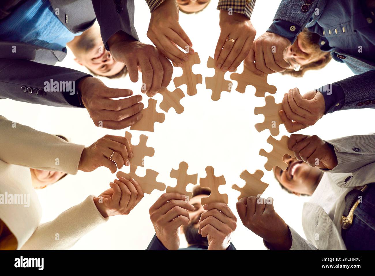 Une équipe diversifiée de gens d'affaires heureux forment un cercle à partir de pièces d'un puzzle Banque D'Images