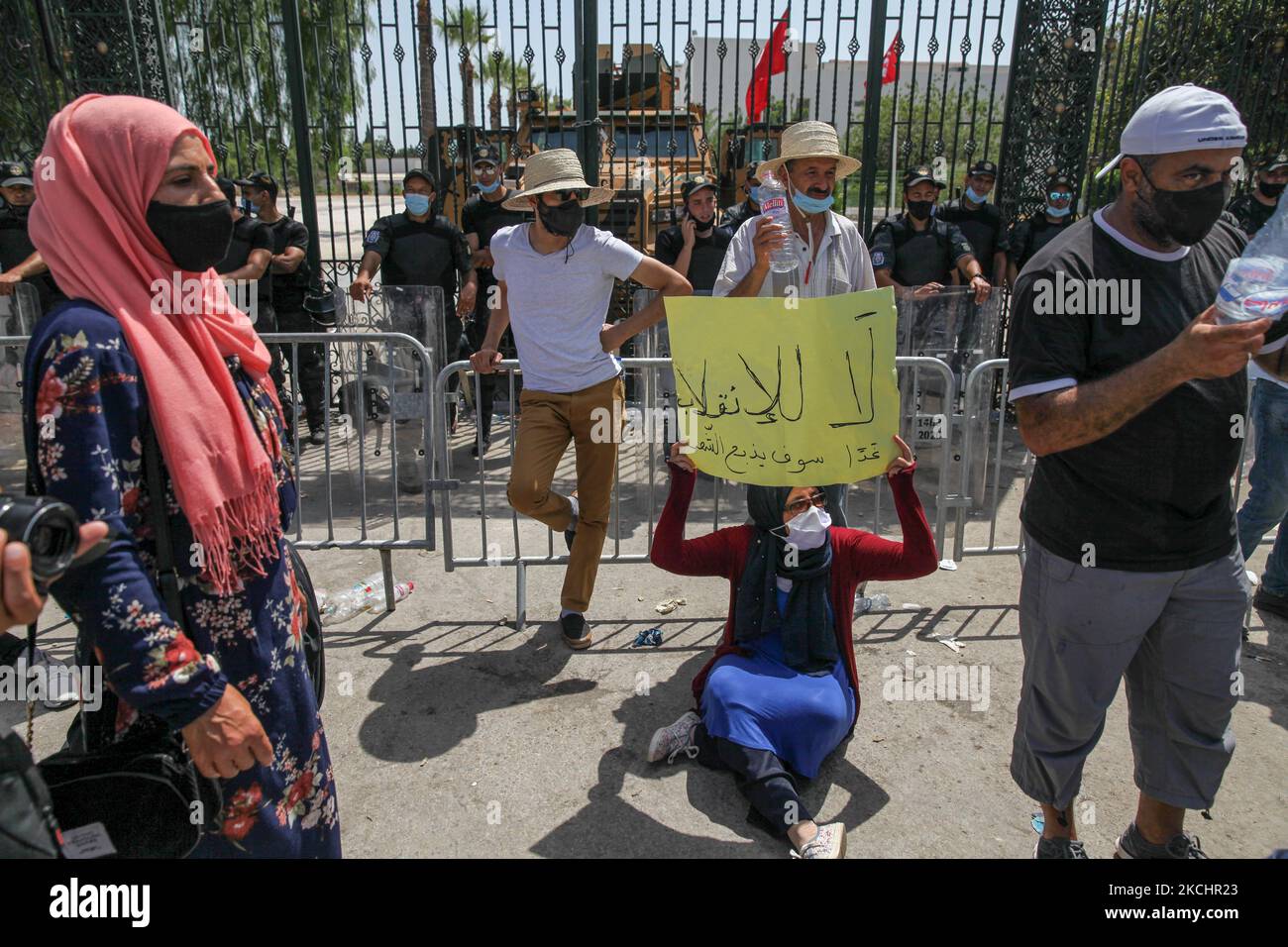 Une femme partisane du parti islamiste Ennahdha pose un écriteau qui se lit dans Arbaic, non au coup d'État, demain le peuple sera fendu, car elle est assise sur le terrain lors d'une protestation assise menée par le président du Parlement tunisien, Rached Ghannouchi, Devant le bâtiment du Parlement tunisien à Bardo, dans la capitale Tunis, Tunisie, sur 26 juillet 2021, après que l'armée l'a empêché d'entrer, Et après la décision du président tunisien Kais de rejeter le gouvernement de Hichem Mechichi, de geler le Parlement et de suspendre l'immunité de tous les membres du Parlement. (Photo de Chehly Ben I Banque D'Images