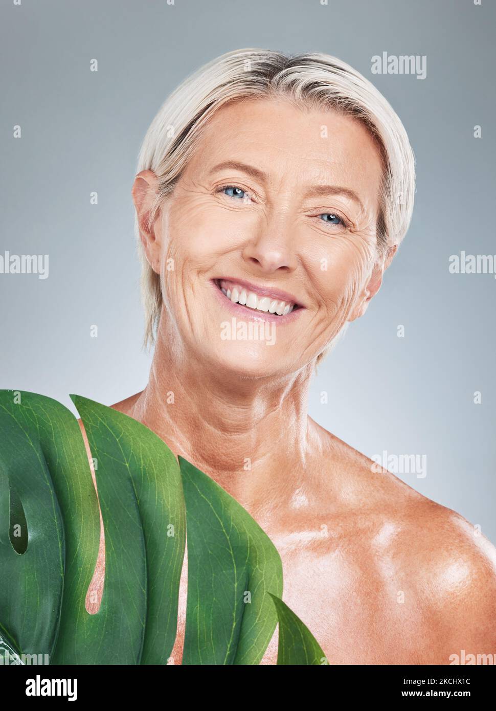 Femme âgée, anti-âge soin de la peau et feuilles avec bonheur avec le fond de studio pour le portrait de bien-être. Modèle pour personnes âgées, cosmétiques, brillance et brillance de la peau Banque D'Images