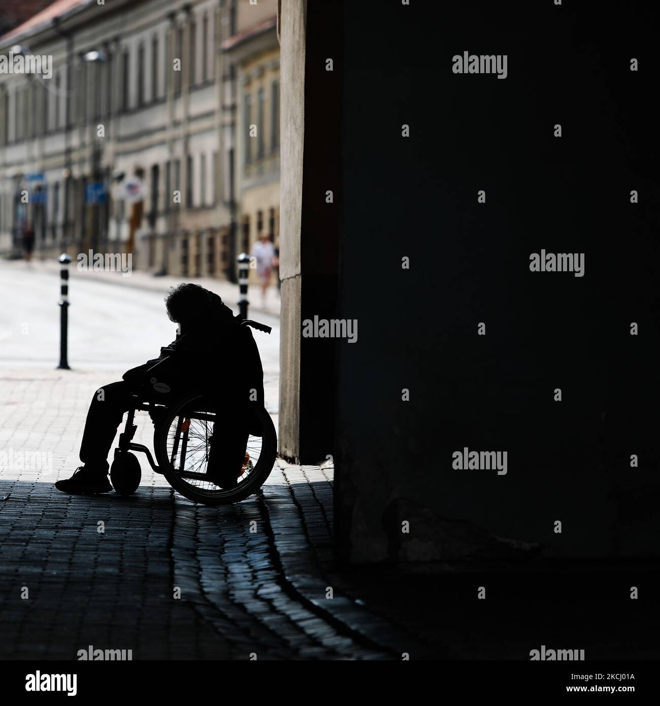 Un homme en fauteuil roulant sous la porte de l'Aube à Vilnius, Lituanie sur 27 juillet 2021. (Photo de Jakub Porzycki/NurPhoto) Banque D'Images