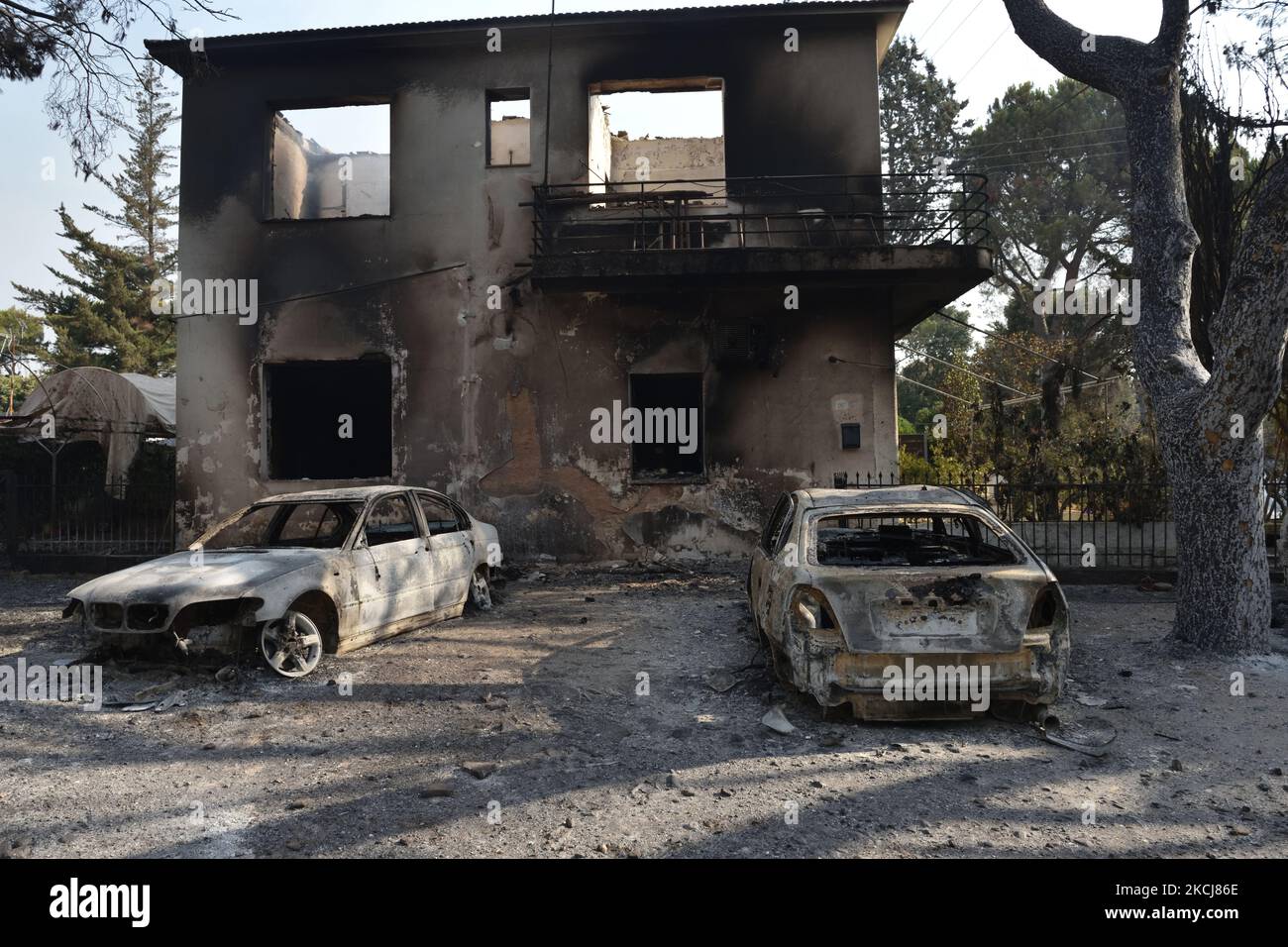 Deux voitures sont détruites devant le bâtiment du club équestre incendié par le feu de forêt dans la banlieue nord d'Athènes, Varimpompi, sur 4 août 2021. (Photo de Nicolas Koutsokostas/NurPhoto) Banque D'Images