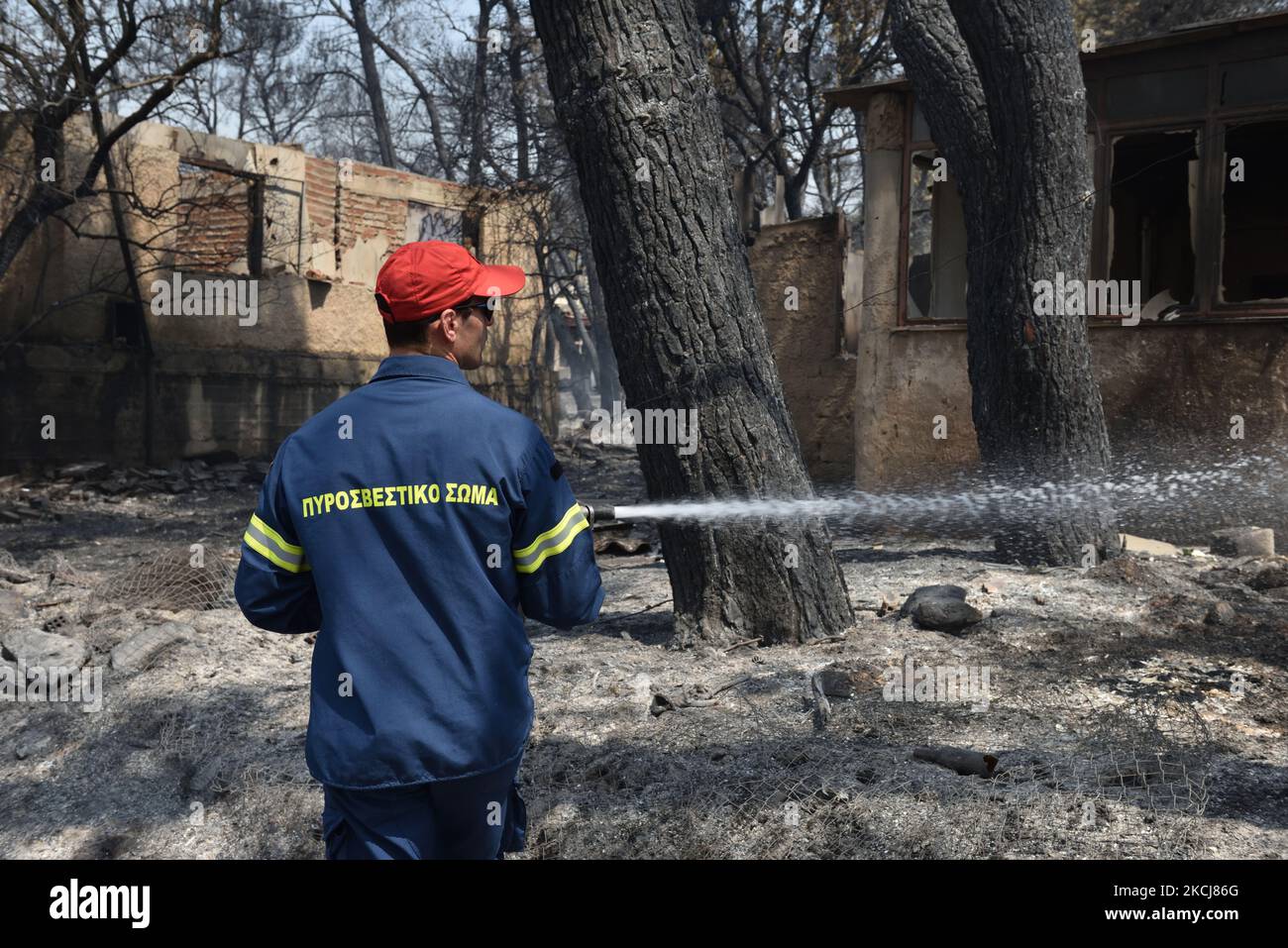 Un pompier vaporise de l'eau pour contenir un feu de forêt dans la banlieue nord d'Athènes, à Varipompi, sur 4 août 2021. (Photo de Nicolas Koutsokostas/NurPhoto) Banque D'Images