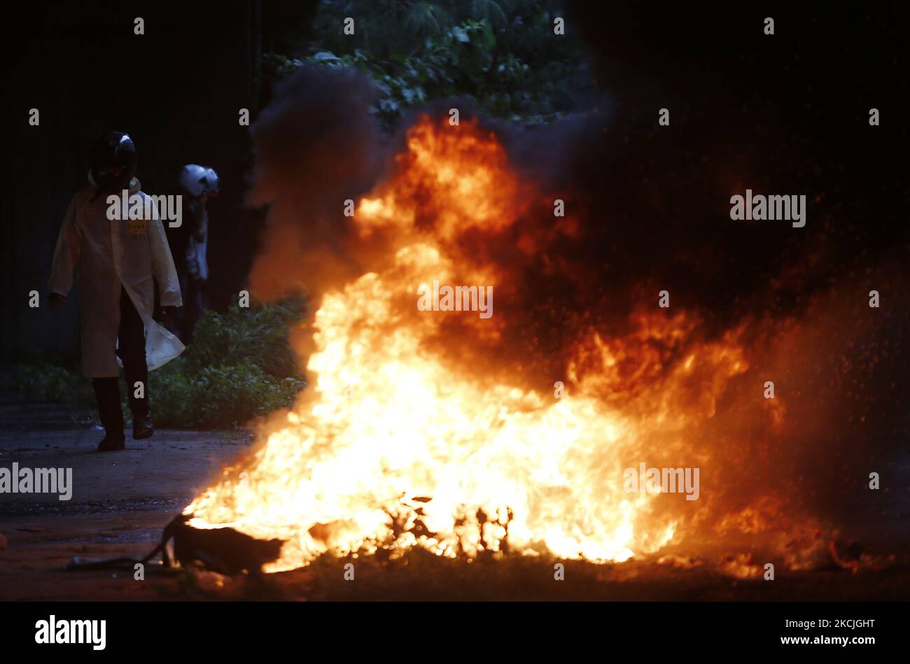 Un manifestant passe devant un incendie pendant la démonstration à l'intersection de DIN Daeng à Bangkok sur 11 août 2021. La police a tiré des gaz lacrymogènes et des balles en caoutchouc pour disperser une autre manifestation antigouvernementale mercredi à Bangkok. La manifestation, organisée par le groupe Tha lu Fah, a débuté à 3pm h au Monument de la victoire. Des centaines de manifestants ont jeté de la peinture sur une ligne de police anti-émeute qui les a affrontés alors qu'ils essayaient de marcher jusqu'à la résidence du Premier ministre Prayut Chan-o-cha au régiment d'infanterie 1st sur Vibhavadi Rangsit Road. (Photo de Chaiwat Subprasom/NurPhoto) Banque D'Images