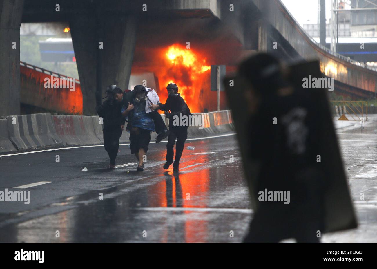 Un manifestant blessé est amené par son ami après des affrontements avec des policiers anti-émeute lors de l'intersection démonstrationat de DIN Daeng à Bangkok sur 11 août 2021. La police a tiré des gaz lacrymogènes et des balles en caoutchouc pour disperser une autre manifestation antigouvernementale mercredi à Bangkok. La manifestation, organisée par le groupe Tha lu Fah, a débuté à 3pm h au Monument de la victoire. Des centaines de manifestants ont jeté de la peinture sur une ligne de police anti-émeute qui les a affrontés alors qu'ils essayaient de marcher jusqu'à la résidence du Premier ministre Prayut Chan-o-cha au régiment d'infanterie 1st sur Vibhavadi Rangsit Road. (Photo de Chaiwat Subprasom Banque D'Images