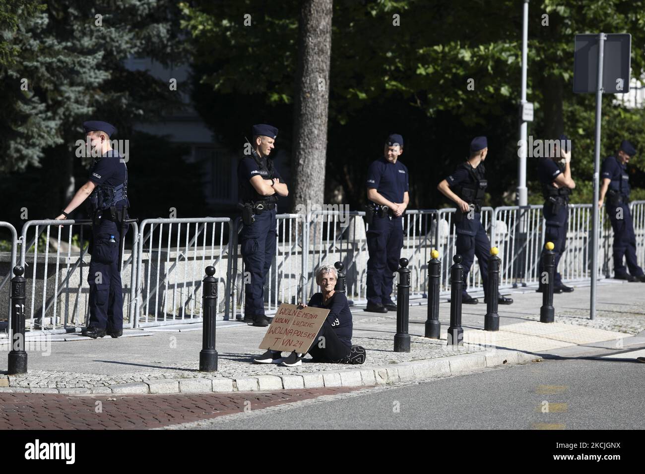 Une femme porte un panneau avec les mots "Free Media" devant la police qui garde l'entrée de la Sejm, Parlement polonais à Varsovie, Pologne sur 11 août 2021. Plusieurs dizaines de personnes ont assisté à un rassemblement devant le Parlement lors d'un vote sur un nouveau projet de loi qui limiterait la propriété étrangère des entreprises médiatiques. Les critiques soutiennent que l'adoption du projet de loi signifiera la fin des médias indépendants en Pologne. La chaîne DE télévision AMÉRICAINE TVN demande le renouvellement de sa licence qui expire en septembre, mais craint que la propriété américaine ne soit mise en place et que le gouvernement polonais achète actuellement les actions Banque D'Images