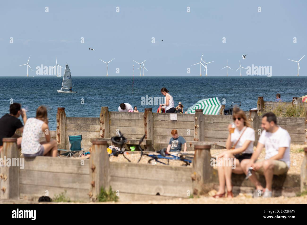 Les vacanciers profitent d'une journée d'été ensoleillée sur la plage de Whitstable, ville côtière du sud-est de l'Angleterre, avec des usines de production d'énergie de Kentish Flats en arrière-plan sur 11 août 2021. Le Royaume-Uni pense à un changement équitable pour un avenir plus durable alors que le GIEC publie son abrégé sur l'influence humaine sur le changement climatique., 2021. Le Royaume-Uni pense à un changement équitable pour un avenir plus durable alors que le GIEC publie son abrégé sur l'influence humaine sur le changement climatique., 2021. Le Royaume-Uni pense à un changement équitable pour un avenir plus durable alors que le GIEC publie son abrégé sur l'influence humaine sur le changement climatique., 2021. Unis Banque D'Images