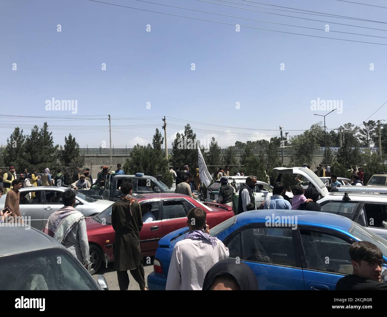 Les gens ont du mal à traverser le mur frontière de l'aéroport international Hamid Karzaï pour fuir le pays après des rumeurs selon lesquelles des pays étrangers évacueraient des personnes même sans visa, après que les talibans aient pris la fuite de Kaboul, en Afghanistan, le 16 août 2021. (Photo par STR/NurPhoto) Banque D'Images