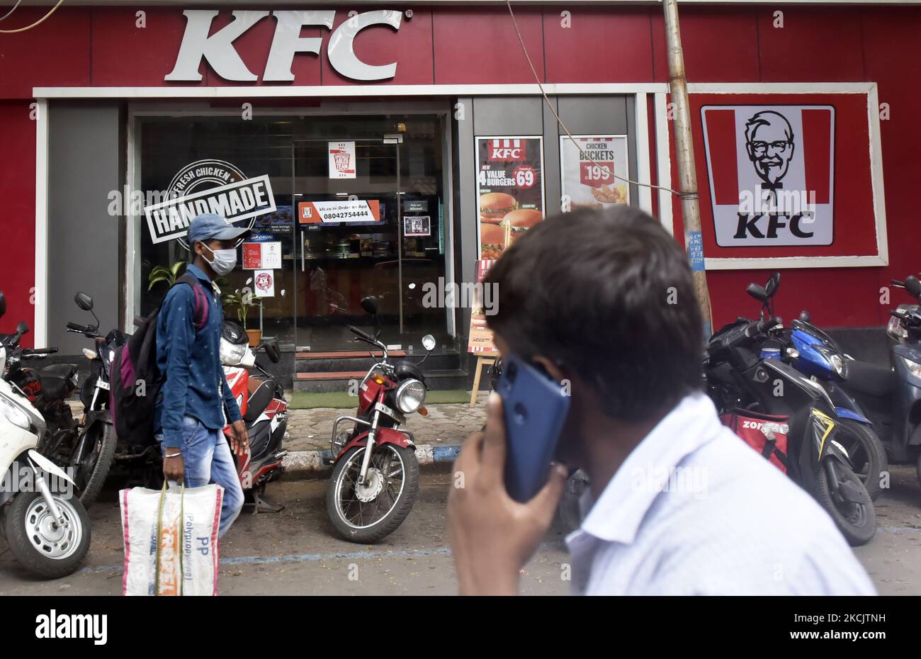 Un homme parle au téléphone passe devant un restaurant KFC à Kolkata, en Inde, le 17 août 2021. Les marques principales de Devyani International, telles que KFC, Pizza Hut et Costa Coffee, contribuent à hauteur de 94 % à ses résultats, tandis que le reste provient des opérations internationales. L'IPO de 1 838-crore par le plus grand franchisé de Pizza Hut, KFC, et Costa Coffee en Inde s'est déroulée de 4 août à 6 août et a été vendue dans la fourchette de prix RS 86-90 selon un rapport des médias indiens. (Photo par Indranil Aditya/NurPhoto) Banque D'Images