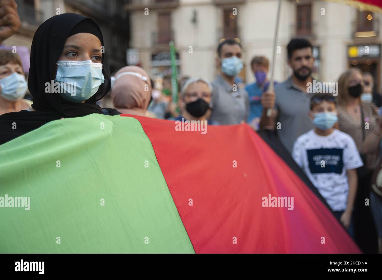 Une fille afghane détient un drapeau afghan pendant la concentration qui va faire connaître Barcelone de la situation en Afghanistan, à Barcelone, Espagne, sur 18 août 2021. (Photo de Charlie Perez/NurPhoto) Banque D'Images