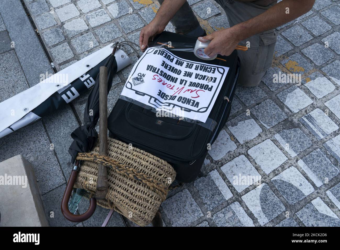 Un participant à la marche contre l'installation de parcs éoliens dans la montagne Cantabrique, met une bannière dans une valise qui symbolise que les parcs éoliens les expulsent de leur vie dans les villes de Cantabrie où ils veulent installer ces parcs éoliens. SANTANDER 08-21-2021 (photo de Joaquin Gomez Sastre/NurPhoto) Banque D'Images