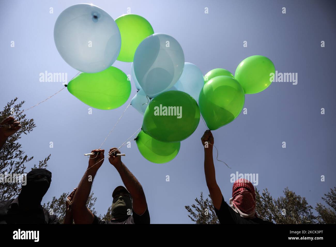 Les Palestiniens masqués préparent des ballons incendiaires près du camp de réfugiés de Bureij à Gaza, le long de la barrière frontalière entre Israël et Gaza, sur 24 août 2021. (Photo de Majdi Fathi/NurPhoto) Banque D'Images