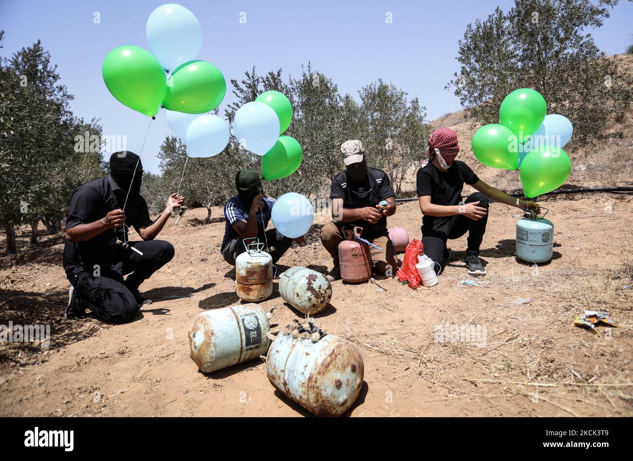 Les Palestiniens masqués préparent des ballons incendiaires près du camp de réfugiés de Bureij à Gaza, le long de la barrière frontalière entre Israël et Gaza, sur 24 août 2021. (Photo de Majdi Fathi/NurPhoto) Banque D'Images