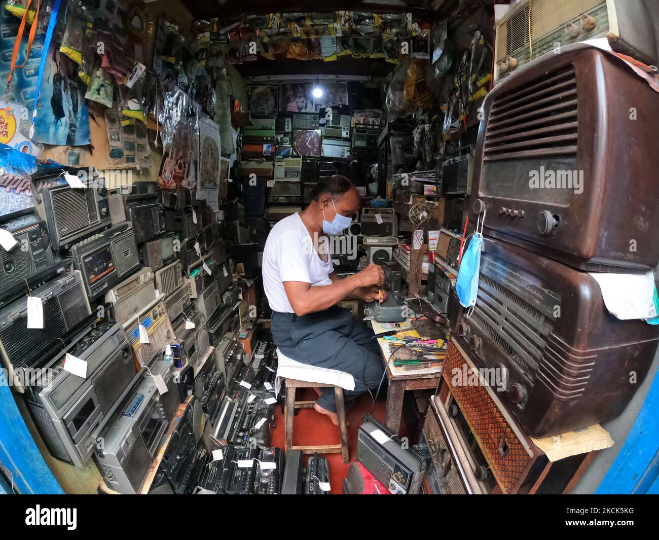 La petite boutique d'Amit Ranjan Karmakar est facile à manquer. Au milieu de l'année 60s, l'homme radio de Kolkata est entouré d'ensembles de radios de toutes tailles et de tous les millésimes. Les anciennes marques se délèrent de sa langue - Bush, Murphy, Phillips, Telefunken... autrefois des noms de famille en Inde, jusqu'à ce que les radios soient passées. Selon sa propre estimation, le plus ancien ensemble de son magasin date de 1944, apporté par un client et jamais récupéré.aujourd'hui, l'entreprise a fait l'objet d'un déferrage, admet-il, bien qu'il soit toujours recherché par ceux qui souhaitent préserver les métiers de la famille. 'Les gens viennent à moi avec des postes de radio appartenant à leurs parents ou grands-parents, un Banque D'Images