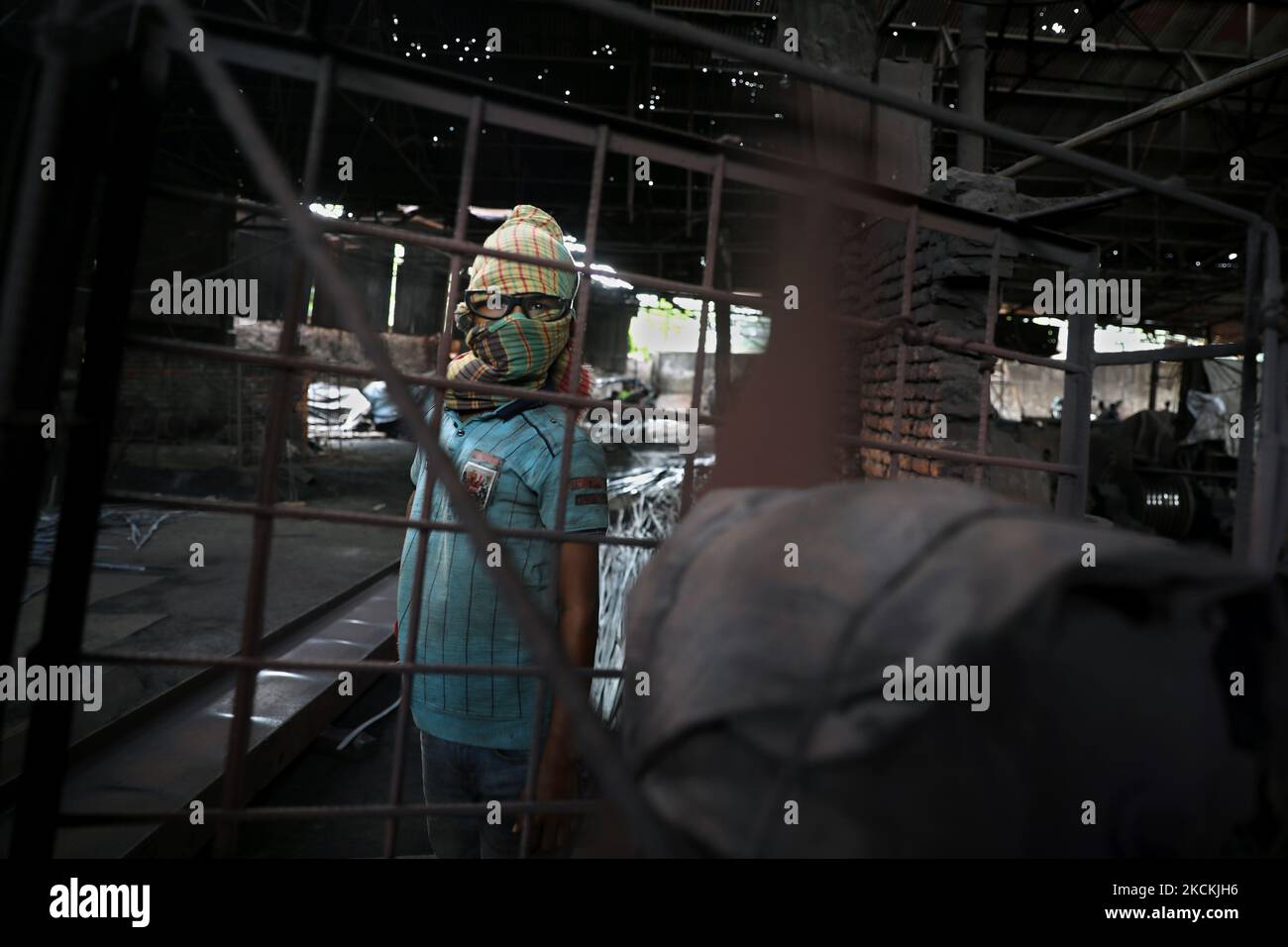 Tanim (12), réagit à la caméra en travaillant dans une usine de recyclage du fer pendant 12 heures par jour pour gagner 20 USD par semaine. La photo a été prise de Popogola à Dhaka, au Bangladesh, sur 30 août 2021. (Photo de Syed Mahamudur Rahman/NurPhoto) Banque D'Images Tanim (12), réagit à la caméra en travaillant dans une usine de recyclage du fer pendant 12 heures par jour pour gagner 20 USD par semaine. La photo a été prise de Popogola à Dhaka, au Bangladesh, sur 30 août 2021. (Photo de Syed Mahamudur Rahman/NurPhoto) Banque D'Images