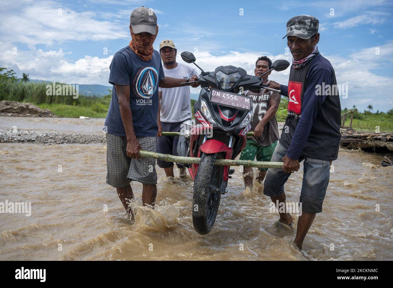 Les résidents lèvent des motos sur une route couverte d'eau de rivière débordante dans le village de Jono Oge, la régence de Sigi, province centrale de Sulawesi, en Indonésie sur 2 septembre 2021. La route reliant plusieurs sous-districts de Sigi Regency a été submergée par des eaux fluviales débordant après de fortes pluies d'intensité suffisante depuis mardi dernier (31 août 2021). Outre les inondations, plusieurs zones de la région ont également été touchées par des catastrophes naturelles telles que les inondations soudaines et les glissements de terrain. (Photo de Basri Marzuki/NurPhoto) Banque D'Images