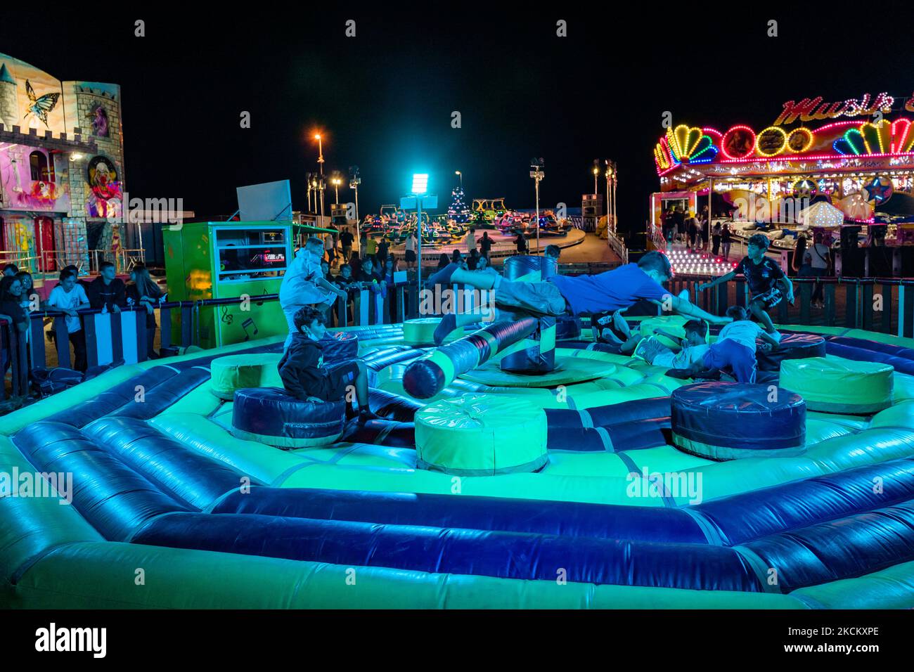 Les garçons ont du plaisir à sauter sur l'obstacle tournant le premier jour de l'ouverture du Luna Park à Molfetta le 4 septembre 2021. A l'occasion de la Fête Patronale de Molfetta et en l'honneur de la Madonna dei Martiri, le Luna Park a été ouvert à la Secca dei Pali, avec des portes d'accès et de sortie, le contrôle de la température d'accès et le contrôle aléatoire des passes vertes selon les instructions de la loi. (Photo par Davide Pischettola/NurPhoto) Banque D'Images
