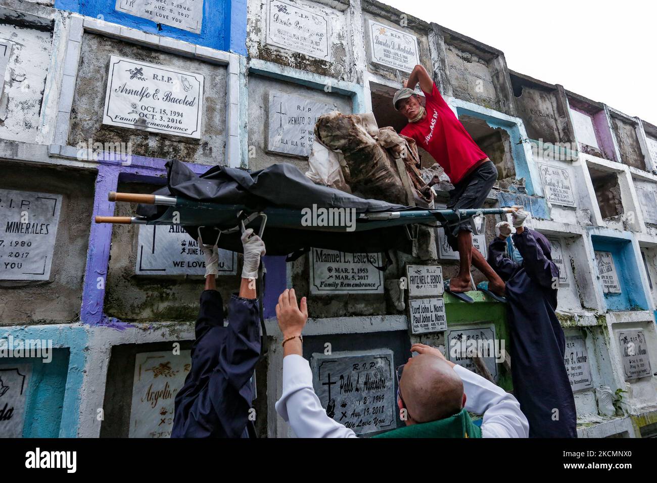 NAVOTAS CITY, Philippines - Un travailleur place les restes d'une victime présumée de la guerre de la drogue dans un sac de corps car ils s'exhument des restes au cimetière de Navotas sur 17 septembre 2021. Plusieurs vestiges ont été exhumés à l'expiration du bail sur leurs tombes. Au 15 septembre dernier, la Cour pénale internationale (CPI) a autorisé une enquête sur le Président Duterte et sa guerre contre la drogue depuis son entrée en fonction le 2016 juillet jusqu'à ce que le 16 mars 2019, lorsque le pays s'est retiré du Statut de Rome qui a créé la CPI, prenne effet. L'enquête portera également sur les meurtres commis dans la ville de Davao, où le président Duterte a servi bo Banque D'Images