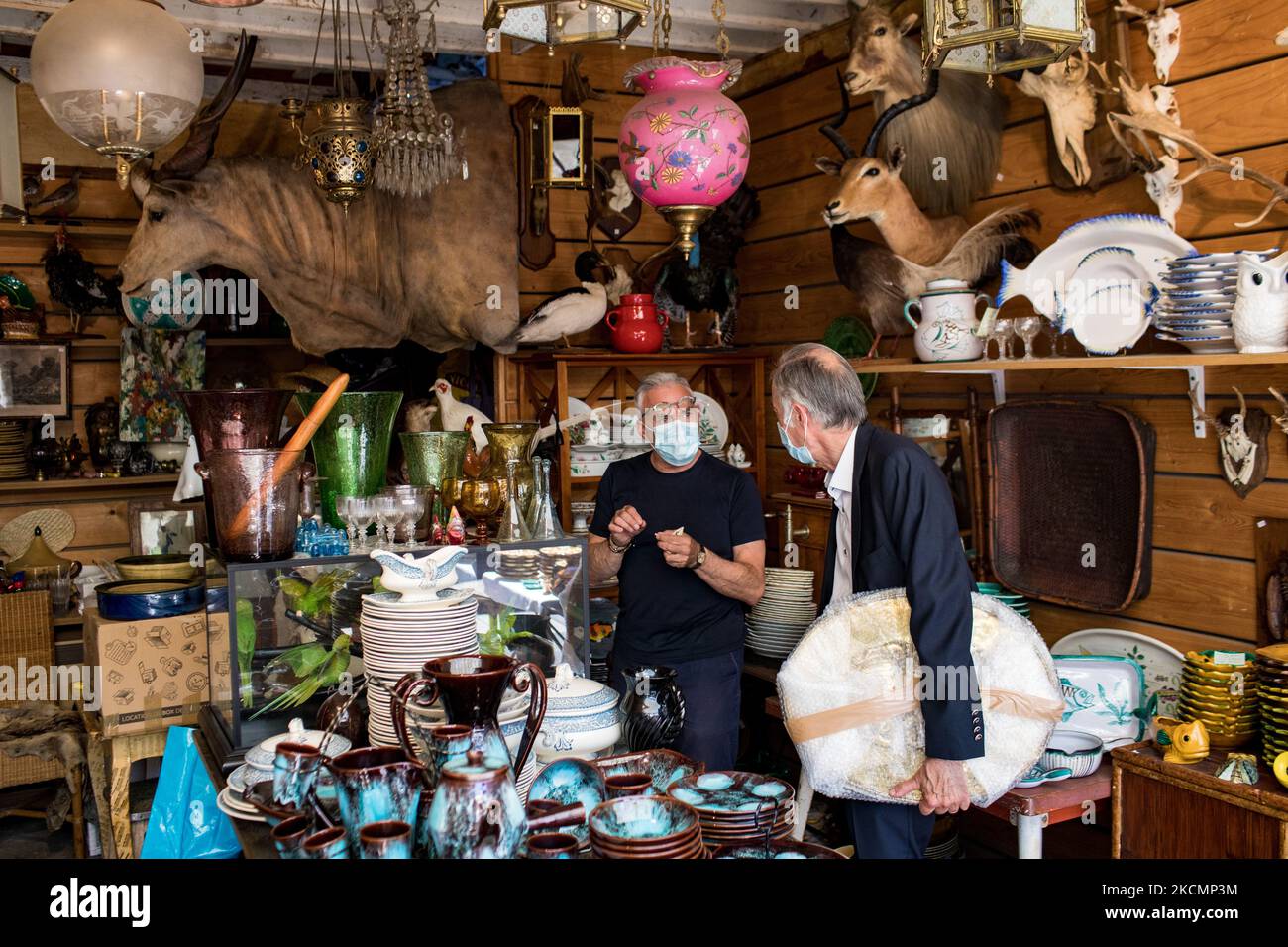 Saint-Ouen, France, le 18 juillet 2021. Un homme regarde les antiquités dans une boutique du marché Paul Bert, dans le marché aux puces de Saint-Ouen. Les différents marchés rassemblent près de 2 000 marchands et couvrent 7 hectares. C'est le plus grand marché d'art et d'antiquités au monde, avec 5 millions de visiteurs par an. Banque D'Images