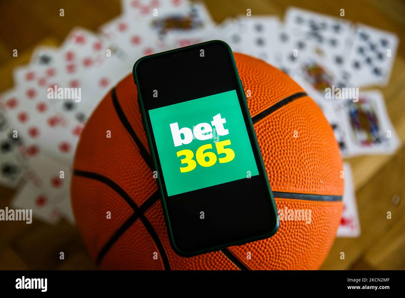 Le logo BET 365 est affiché sur un téléphone mobile, le basket-ball et les cartes à jouer sont visibles dans cette photo d'illustration prise à Cracovie, en Pologne, sur 21 septembre 2021. (Photo de Jakub Porzycki/NurPhoto) Banque D'Images