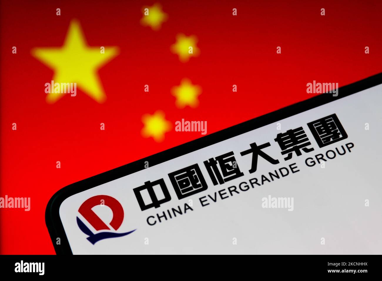 Le logo du groupe China Evergrande est affiché sur l'écran du téléphone et le drapeau chinois est affiché en arrière-plan sur cette photo prise à Cracovie, en Pologne, sur 27 septembre 2021. (Photo de Jakub Porzycki/NurPhoto) Banque D'Images