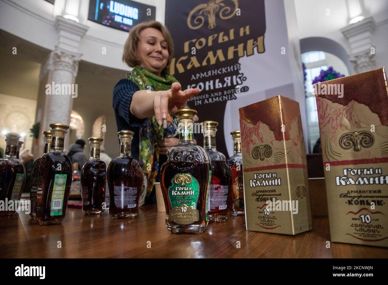 Moscou, Russie. 4th novembre 2022 Une femme offre aux visiteurs de goûter le cognac arménien d'époque 'montagnes et pierres' au festival des vins et spiritueux 'Armwinefest 2022' dans le pavillon arménien du VDNH à Moscou, Russie Banque D'Images