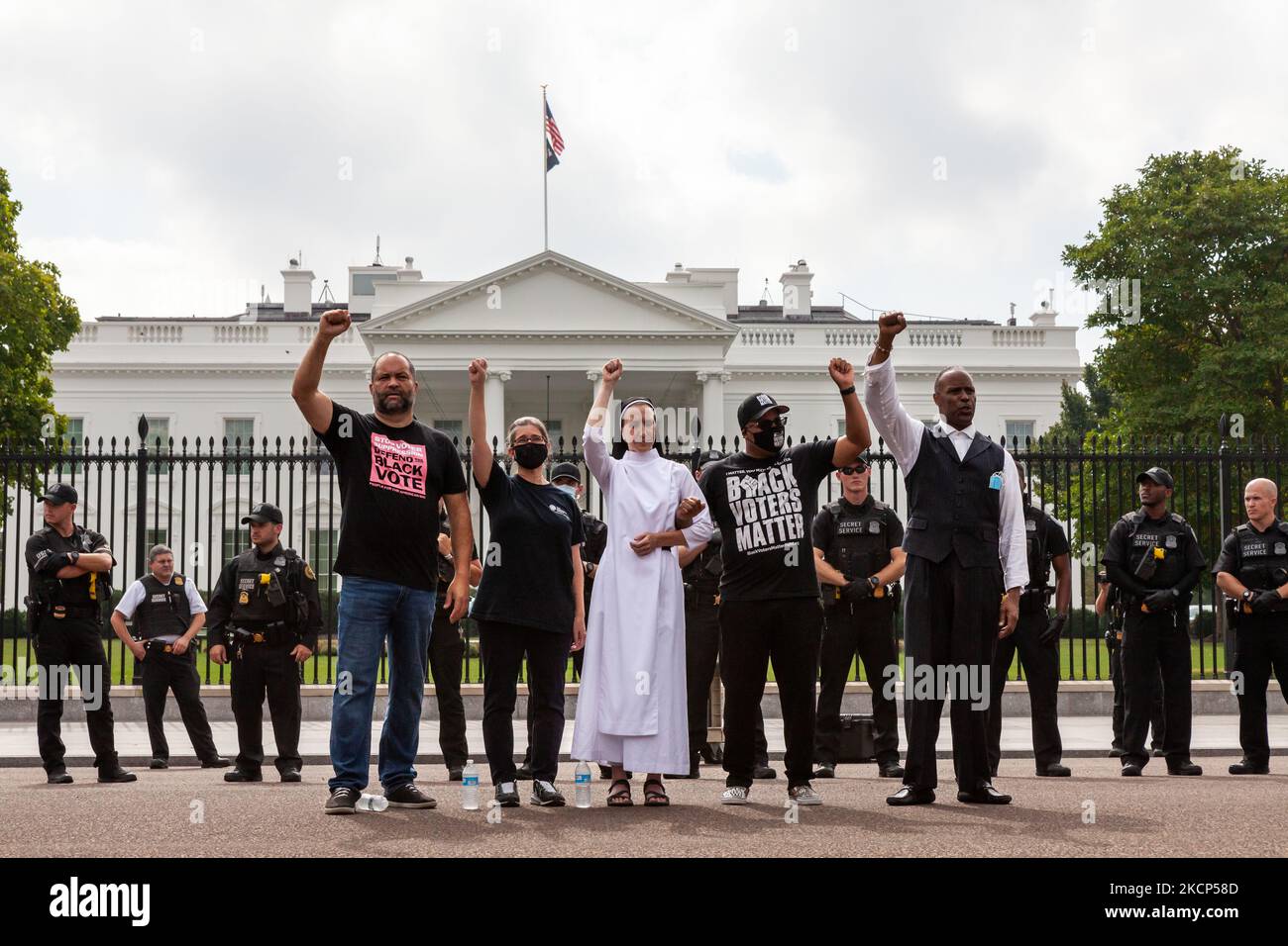 Les militants du droit de vote élèvent leurs poings en attendant leur arrestation par le Service secret des États-Unis lors d'une action de désobéissance civile à la Maison Blanche. Ils exigent que l'Administration Biden prenne l'initiative en matière de droit de vote et font pression sur le Congrès pour qu'il vote une législation protégeant le droit de vote. Première rangée, de gauche à droite : Ben jaloux des gens pour la voie américaine, Noelle Damico du cercle des travailleurs, soeur Quincy Howard de la démocratie fidèle, Cliff Albright des électeurs noirs comptent, et le Pasteur Lewis Logan. (Photo d'Allison Bailey/NurPhoto) Banque D'Images Les militants du droit de vote élèvent leurs poings en attendant leur arrestation par le Service secret des États-Unis lors d'une action de désobéissance civile à la Maison Blanche. Ils exigent que l'Administration Biden prenne l'initiative en matière de droit de vote et font pression sur le Congrès pour qu'il vote une législation protégeant le droit de vote. Première rangée, de gauche à droite : Ben jaloux des gens pour la voie américaine, Noelle Damico du cercle des travailleurs, soeur Quincy Howard de la démocratie fidèle, Cliff Albright des électeurs noirs comptent, et le Pasteur Lewis Logan. (Photo d'Allison Bailey/NurPhoto) Banque D'Images