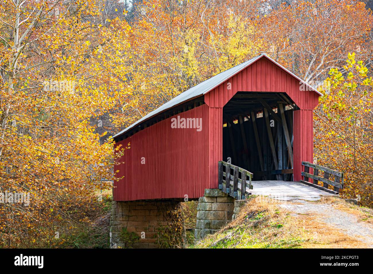 Pont couvert traditionnel rouge entouré d'un feuillage d'automne lumineux dans les Appalaches rurales. Banque D'Images
