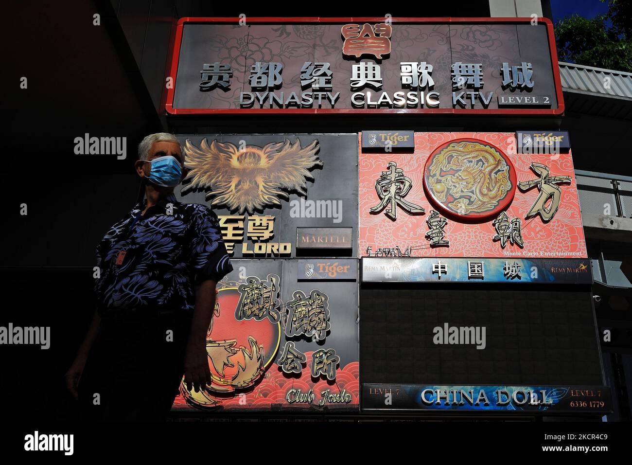 Un homme portant un masque de protection passe devant les panneaux publicitaires des discothèques sur 21 octobre 2021 à Singapour. (Photo de Suhaimi Abdullah/NurPhoto) Banque D'Images