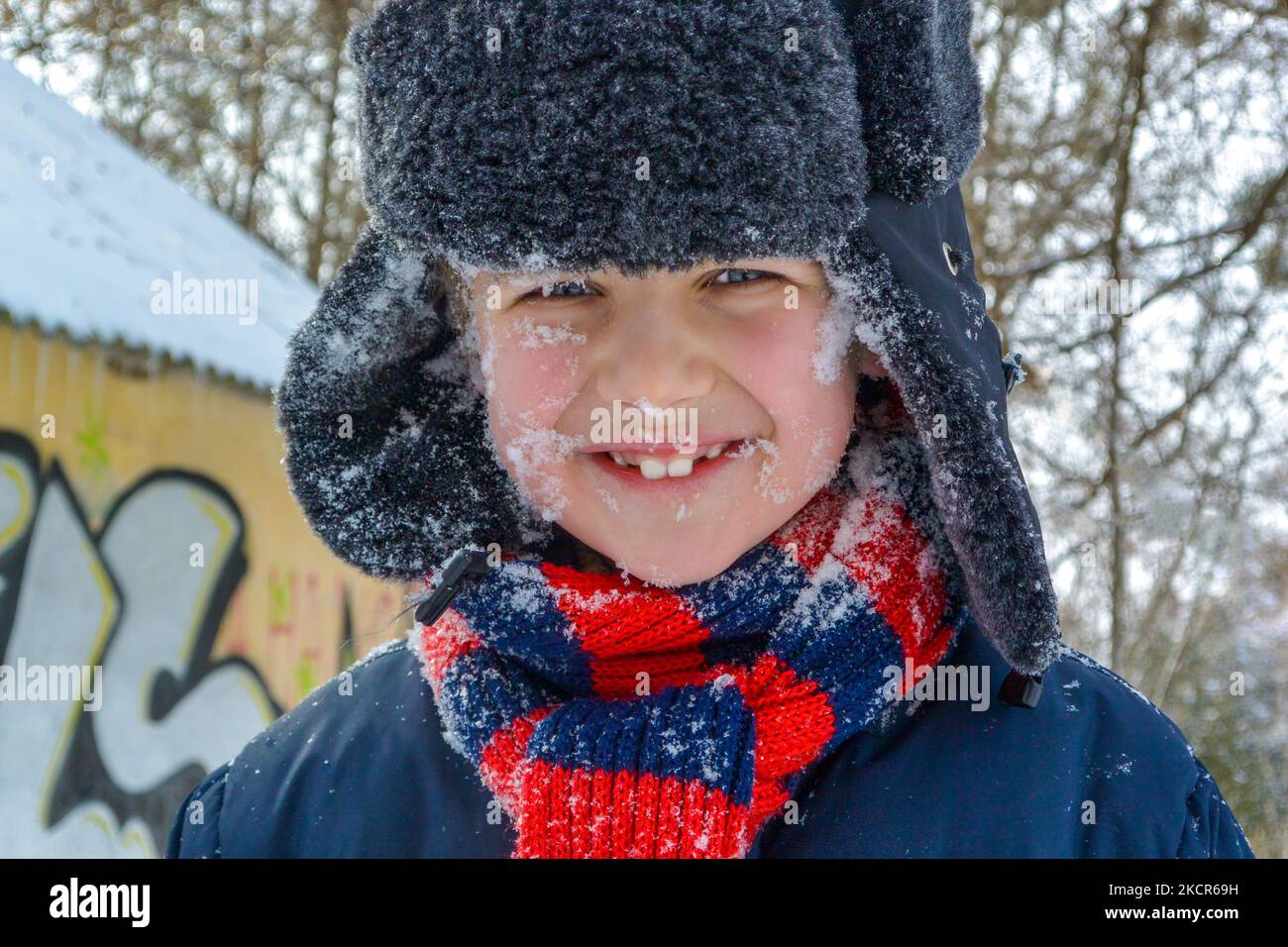 Joyeux garçon souriant à l'extérieur en hiver. Activités d'hiver en plein air, vacances d'hiver. Temps en famille Banque D'Images