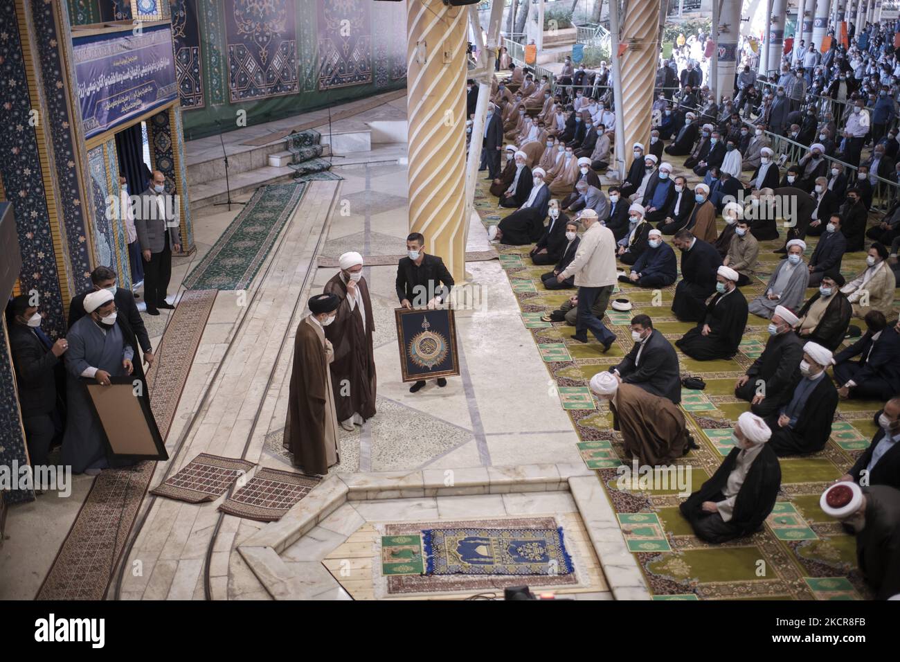 Mohammad Reza Garai (C), champion du monde de lutte iranienne 2021, détient une œuvre encadrée tandis que les religieux iraniens l'applaudit lors des cérémonies de prières du vendredi à l'Université de Téhéran, dans le contexte de la nouvelle épidémie de coronavirus (COVID-19) en Iran, au 22 octobre 2021. Les prières du vendredi de Téhéran se sont de nouveau tenues à l’Université de Téhéran vingt mois après l’épidémie de COVID-19 en Iran. (Photo de Morteza Nikoubazl/NurPhoto) Banque D'Images