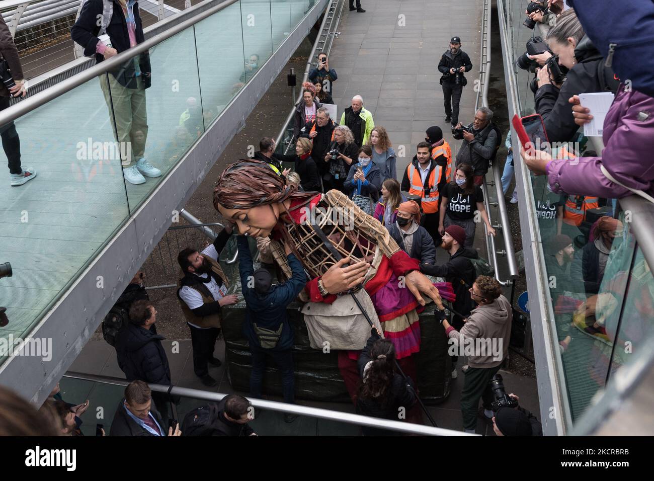 LONDRES, ROYAUME-UNI - 23 OCTOBRE 2021 : Little Amal, marionnette géante de 3,5 mètres de haut représentant un enfant réfugié syrien de neuf ans, est transporté à l'extérieur de Tate Modern sur 23 octobre 2021, à Londres, en Angleterre. Little Amal, conçu par la Handspring Puppet Company, fait partie du projet « The Walk » du théâtre britannique Good chance qui effectue un voyage de 8 000 km de Turquie au Royaume-Uni pour attirer l'attention sur les besoins urgents des jeunes réfugiés. (Photo de Wiktor Szymanowicz/NurPhoto) Banque D'Images