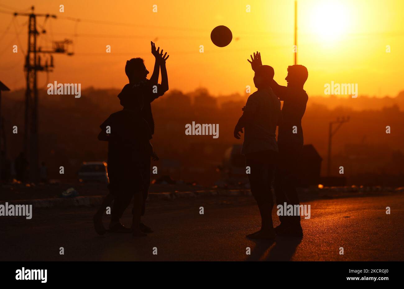 Des jeunes Palestiniens jouent avec une balle au coucher du soleil dans le nord de la bande de Gaza, sur 25 octobre 2021. (Photo de Majdi Fathi/NurPhoto) Banque D'Images