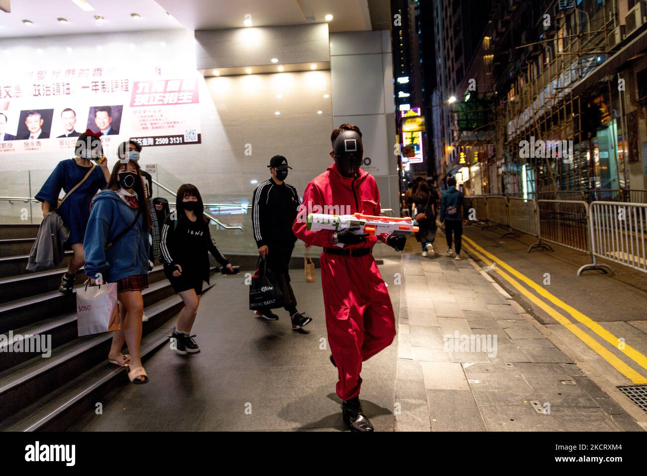 Un jeune homme avec un costume de Squid Game Guard et un fusil de nerf est vu dans le centre de Hong Kong, à Hong Kong, en Chine, sur 30 octobre 2021. (Photo de Marc Fernandes/NurPhoto) Banque D'Images