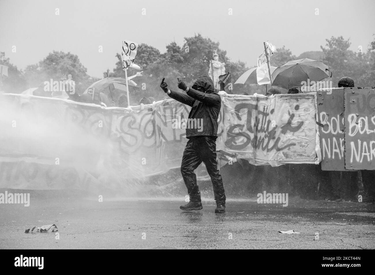 (NOTE DE LA RÉDACTION: L'image a été convertie en noir et blanc) un manifestant montre le doigt du milieu à la police tout en étant baigné avec une borne d'incendie, à Padoue, en Italie, sur 1 novembre 2021. Le Président brésilien Jair Bolsonaro a reçu la citoyenneté honoraire à Anguillara, une ville de la province de Padoue. La police a utilisé des poteaux incendie et des matraques pour chasser les manifestants qui ont tenté de traverser le point de contrôle. (Photo de Roberto Silvino/NurPhoto) Banque D'Images