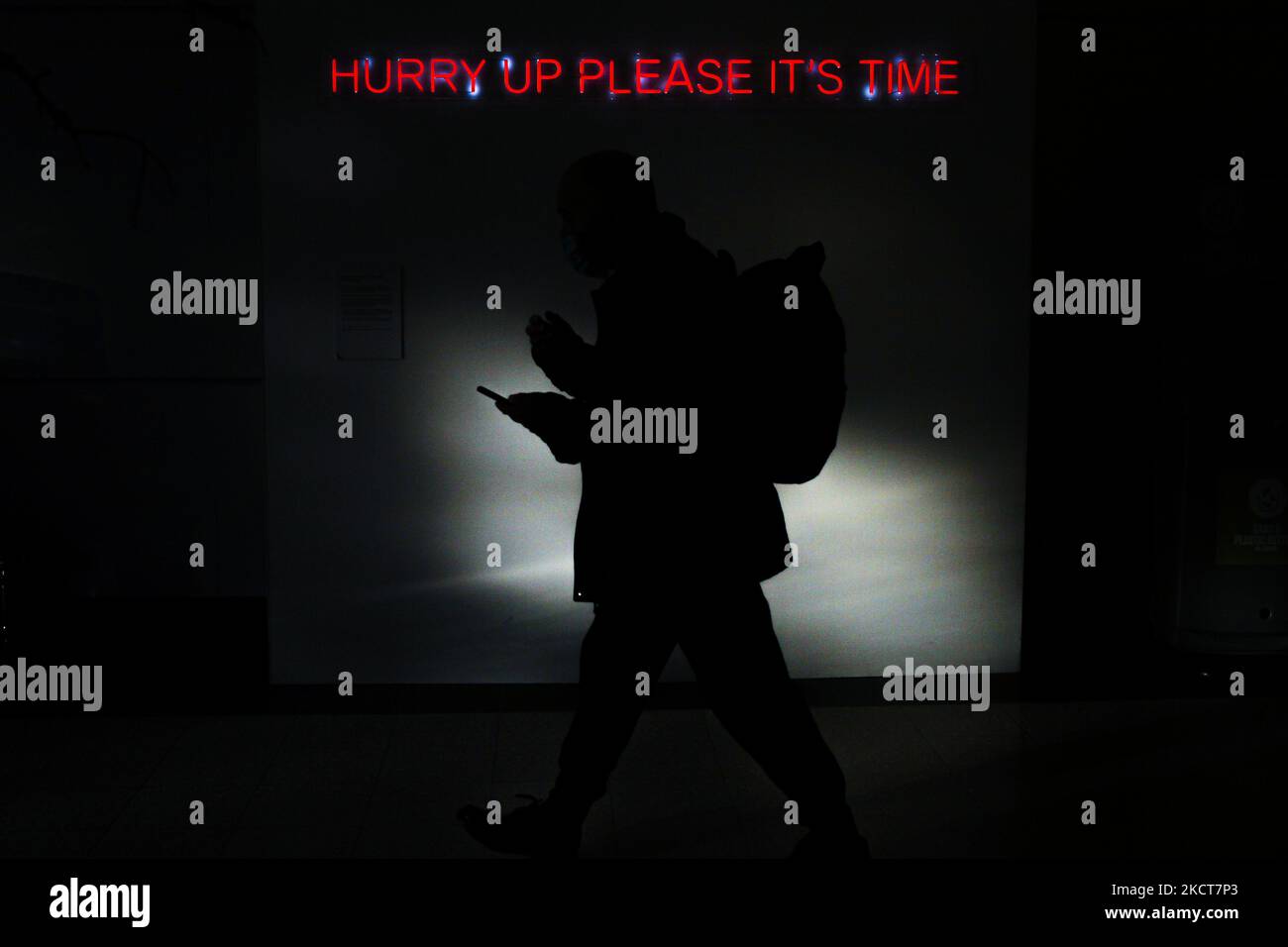 Un délégué passe devant un panneau au néon disant « dépêchez-vous, s'il vous plaît, c'est l'heure » le cinquième jour de la Conférence des Nations Unies sur les changements climatiques de la CdP 26 sur 04 novembre 2021 à Glasgow, en Écosse. (Photo par Ewan Bootman/NurPhoto) Banque D'Images